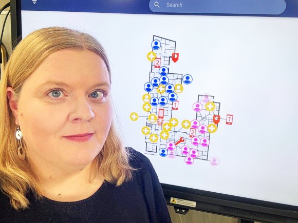 Etualalla Elina Häivälä, taustalla näkymä järjestelmään 
